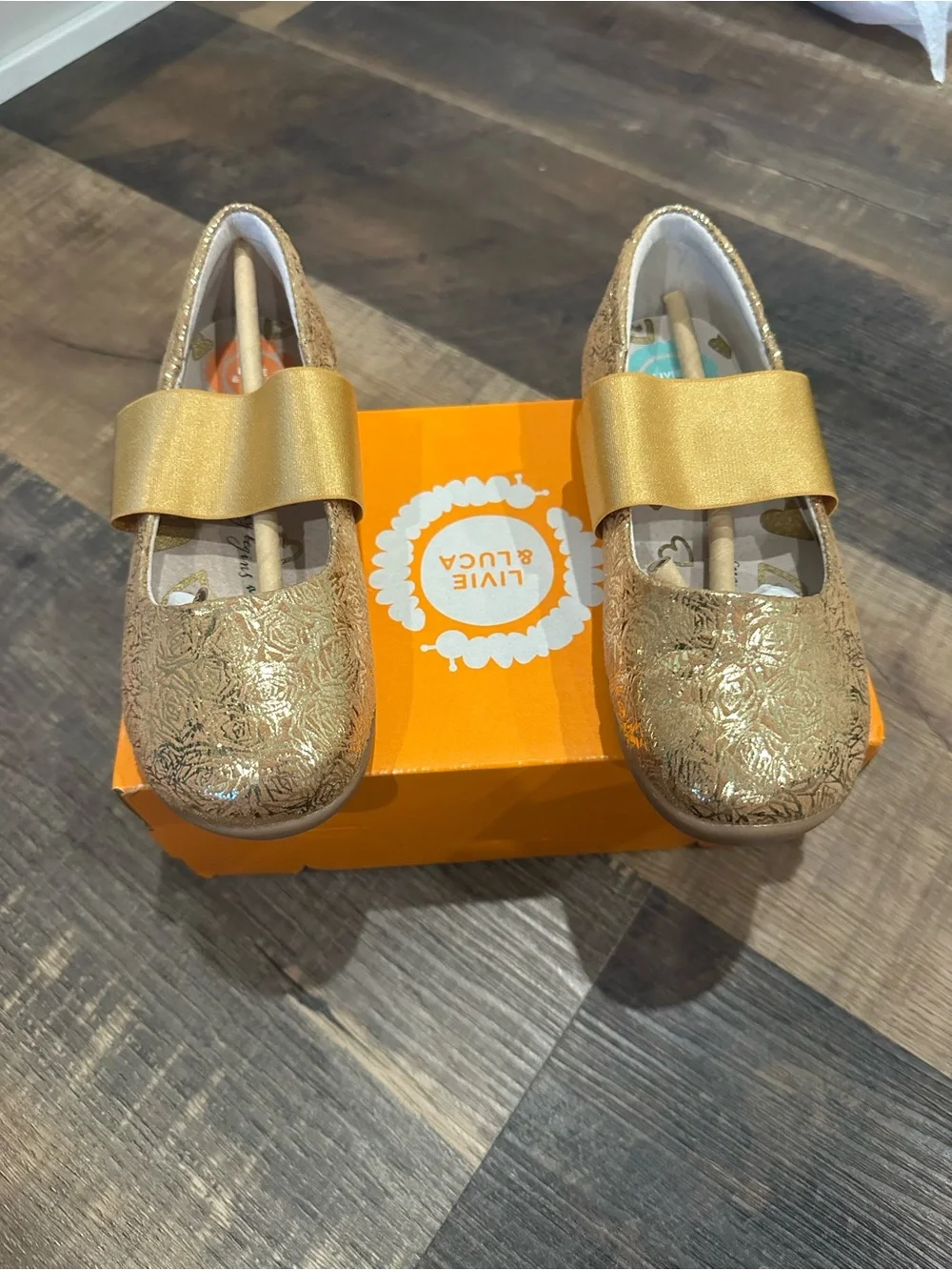 Livie & Luca Girls' Metallic Gold Embossed Mary Janes with Bow Strap